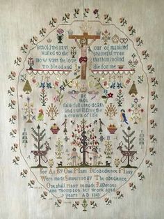 a cross - stitch sample with the words and symbols on it, framed in white linen