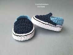 two crocheted slippers with blue and white stripes on the bottom one has a black stripe down the middle