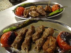 two metal plates filled with meat and vegetables