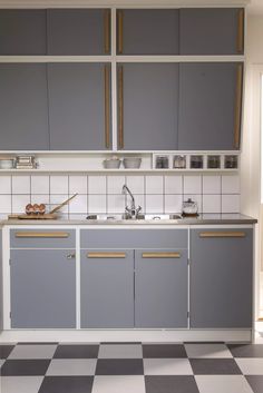 a kitchen with grey cabinets and checkered flooring