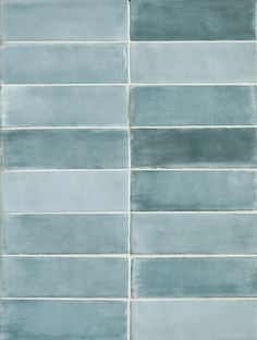 a blue tile wall that has been painted with different shades of gray and light blue