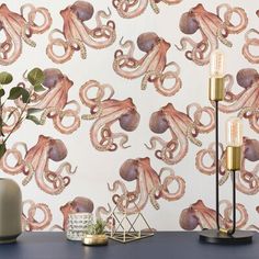 an octopus wallpaper with gold accents on a blue table next to a lamp and potted plant