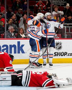 two hockey players are congratulating each other on the ice as fans look on