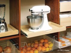 a kitchen shelf with an electric mixer and oranges