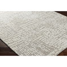 an area rug with wooden floors and wood flooring in the background, it is made from