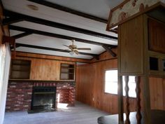 an empty room with wood paneling and a ceiling fan