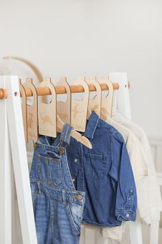 clothes hanging on wooden hangers in a white room