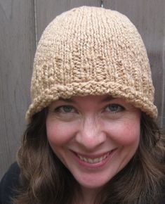 a smiling woman wearing a knitted hat