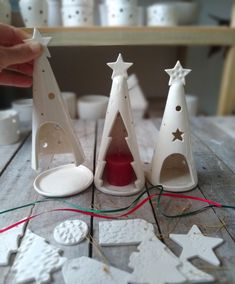 three white ceramic christmas trees on a wooden table