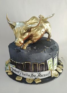 a gold bull statue on top of a black cake