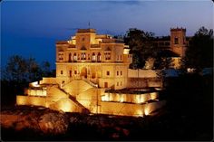 a large building lit up at night with lights on it's walls and windows