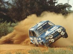 a blue truck making a sharp turn in the dirt