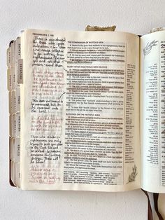 an open book with writing on it sitting on top of a white table next to a pair of scissors