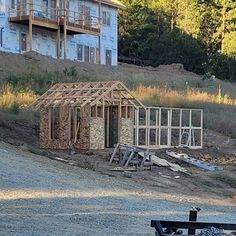 a house being built on the side of a hill with construction equipment in front of it