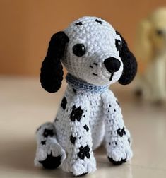 a crocheted dog sitting on top of a table next to a stuffed animal