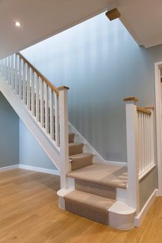 an empty staircase in a house with blue walls and wood floors, leading to the second floor