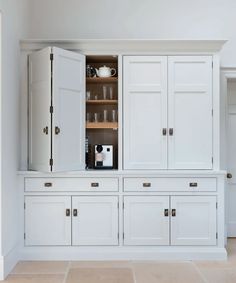 a kitchen with white cupboards and glassware