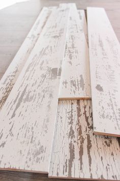 some white wood planks laying on top of a wooden floor with paint chipping off them