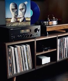 a record player sitting on top of a wooden shelf