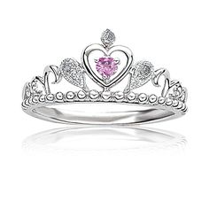 a tiara ring with a pink heart on the front and two white diamonds in the middle