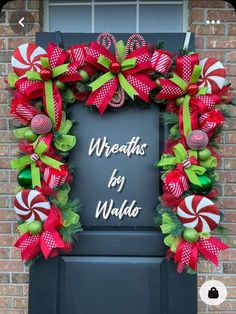 a christmas wreath with candy canes and bows hanging on the front door to welcome guests