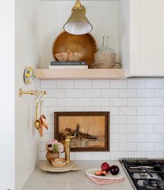 a kitchen with white cabinets and marble counter tops, including an oven hood over the stove