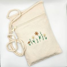 Hello! Welcome to my shop 🥰 This beautiful, hand embroidered phone purse is perfect for all seasons and makes a wonderful gift or even if you just want to treat yourself! PRODUCT DESCRIPTION: *Durable 100% cotton *Zippered front closure *22inch drop handle **BEST USED FOR SHOULDER CARRYING OR CROSSBODY PURSE DIMENSIONS: *9x5inches (22.86cm x 12.7cm) * All orders are packed as minimally as possible while still protecting your order in support of sustainability. Thank you for the love and support! ✉Contact Me! I reply regularly. *If you have any further queries or request. *If you don't see the quantities you need, send me a message, or *If you are interested in custom inquiries, please contact me. Connect with me on Instagram @rebeccaleeboutique  Contact Email: rebeccaleeboutique@gmail.com Floral Embroidered Pouch Bag, Flowers Beige, Pouch Handmade, Boho Garden, Garden Pattern, Minimalist Flowers, Purse Crossbody, Phone Purse, Phone Pouch