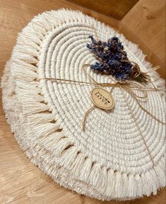 a piece of white wicker with a tag on it sitting on top of a wooden table