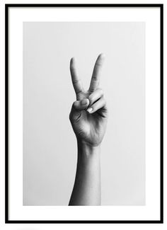 a black and white photo of a person's hand making the v sign with their fingers