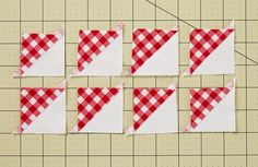 four pieces of red and white fabric are laid out on a cutting board to be sewn together