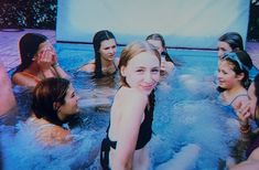 a group of women in a pool with one woman holding her hand up to her face