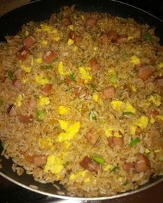 a pan filled with rice and vegetables on top of a stove