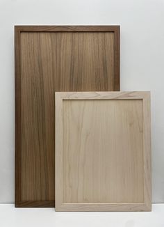 two wooden frames sitting next to each other on a white surface with no one in it