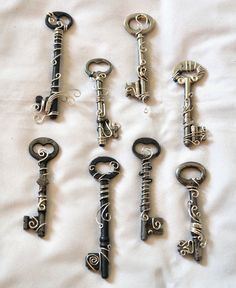 seven antique keys are lined up on a sheet