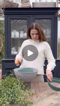 a woman in a white sweater is making a bowl