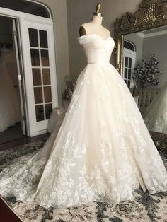 a wedding dress on display in front of a mirror