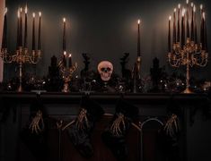 a fireplace decorated for halloween with candles and skulls