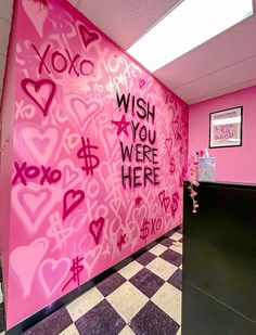 a pink wall with lots of hearts and words painted on it in an office lobby