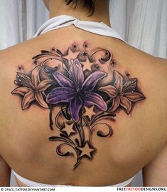 a woman's back tattoo with flowers on it