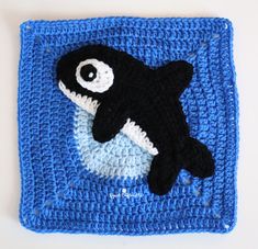 a crocheted square with a black and white orca whale in the center