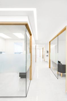 an empty white room with glass walls and doors