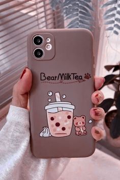 a person holding up a phone case with a drink on the front and bear milkshake on the back