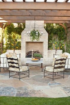 an outdoor living area with chairs and a fire place