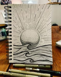 a spiral notebook with an image of the sun and ocean on it