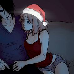 a man sitting next to a woman on top of a couch wearing a santa hat