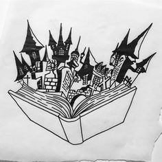 an open book with some black and white drawings on it's pages in front of a castle