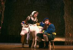 two people are sitting on a white horse