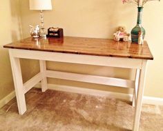 a white table with a wooden top and two vases sitting on it's side