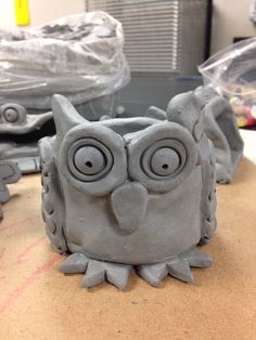 an owl made out of clay sitting on top of a cardboard box next to other items