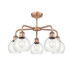 three light chandelier with glass globes in an antique brass finish and frosted glass shades